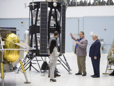 In this handout photograph obtained courtesy of NASA, VP of Research and Development of Intuitive Machines, Tim Crain (second right) speaks with NASA Associate Administrator, Science Mission Directorate, Thomas Zurbuchen (2nd-L) about their lunar lander, Friday, May 31, 2019 at Goddard Space Flight Center in Maryland. 