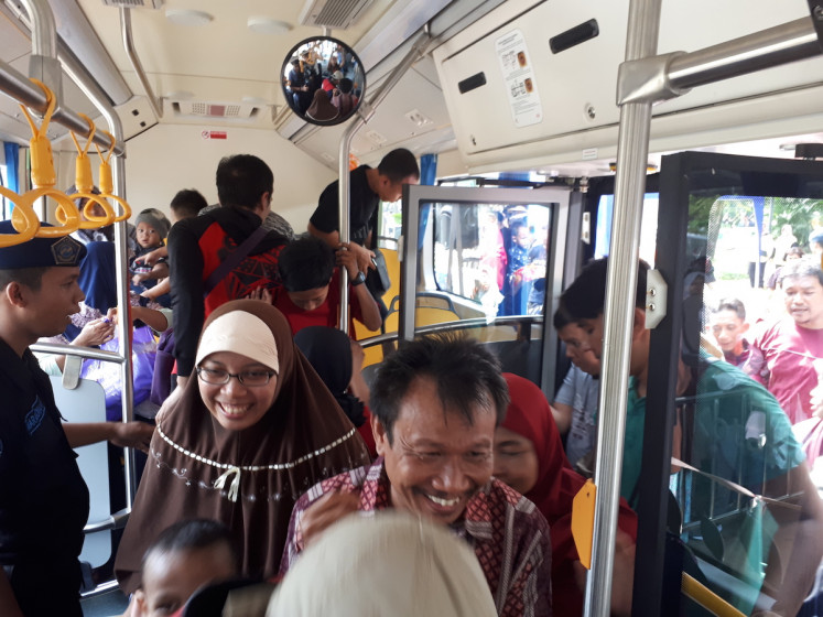 Passengers board a Transjakarta electric bus on June 8 at the National Monument in Central Jakarta. The trial ends on June 9.