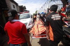 Recovery: Palang Hitam members take an unidentified body to an ambulance. JP/Iqbal Yuwansyah