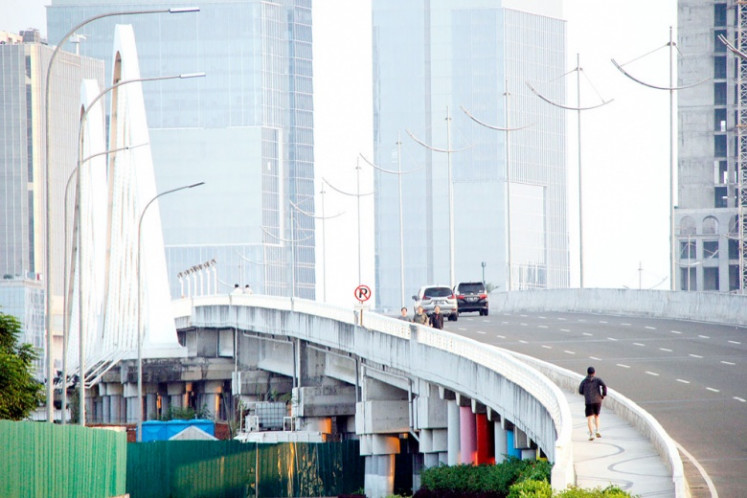 A man jogs on June 12, 2019, along a bridge connecting Jakarta and Maju Beach in Pantai Indah Kapuk 2, built on an artificial island.