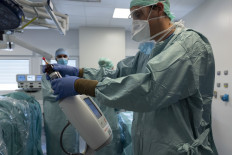 A surgeon prepares a syringe prior to administering chemotherapy on June 7, 2019, at the Georges-Francois Leclerc centre in Dijon, central-eastern France, as he treats a patient with a pressurised intraperitoneal aerosol chemotherapy (PIPAC) to reduce peritoneal metastases of pancreas and biliary tract cancer. 