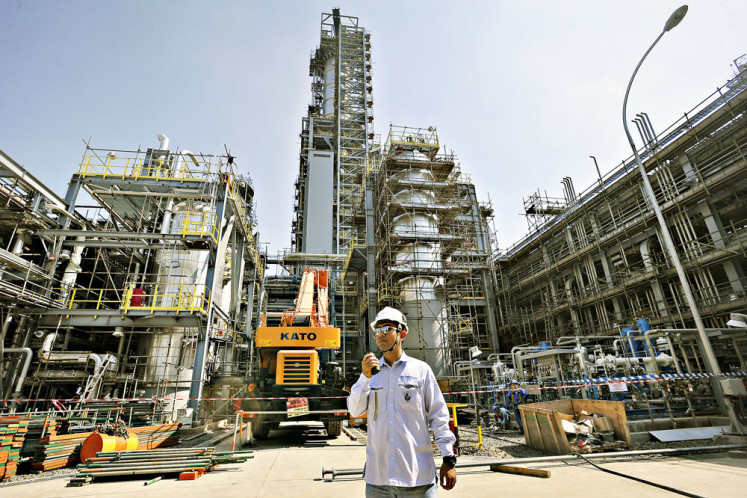 An employee uses a walkie-talkie at the site of a factory under construction for petrochemical company PT Chandra Asri Petrochemical in Cilegon, Banten, in 2019.