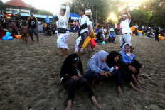 Harmonious: Balinese Hindu adherents clad in white walk by Muslims celebrating tradition on Sanur Beach in Bali. JP/ Zul Trio Anggono