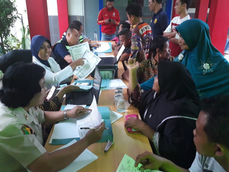 Victims' families communicate with officials about the identification process at a hospital in Medan on June 22.