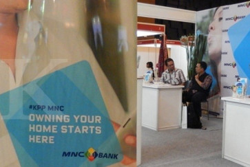 Customers talk while waiting in MNC Bank's office in Jakarta. 