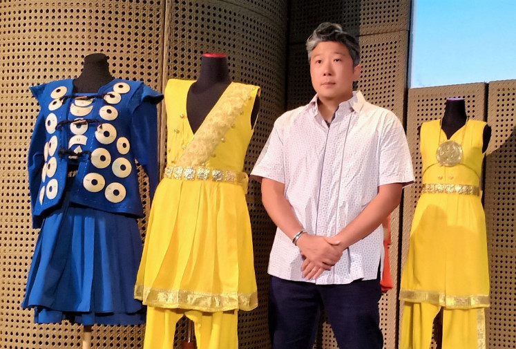 Artisan: Textile design and costume coordinator Airlangga Komara poses with the show's handmade costumes. The fabrics alone took up to six months to complete.