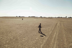 Local children walk toward a small village in the Thar Desert.  JP/Irene Barlian