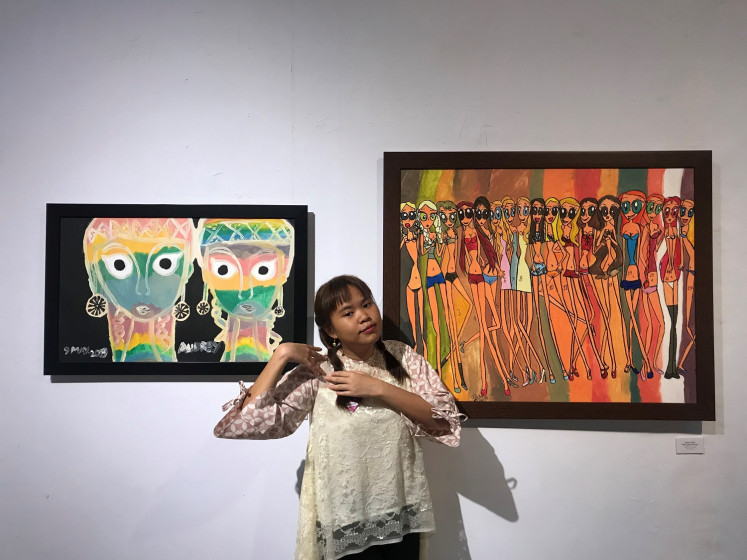 Audrey Angesti with her two paintings, 'The Glow in The Dark Girls' and 'The Girls Power' in the Colors of My World exhibition in Bentara Budaya Jakarta, West Jakarta, on July 4. 