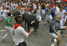 Participants run next to Puerto de San Lorenzo fighting bulls during the first bullrun of the San Fermin festival in Pamplona, northern Spain on July 7, 2019.