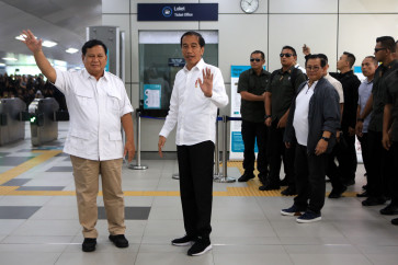 Gerindra Party chairman Prabowo Subianto (left) and President Joko "Jokowi" Widodo greets journalists during their meeting at MRT station in Lebak Bulus, South Jakarta on July 13.