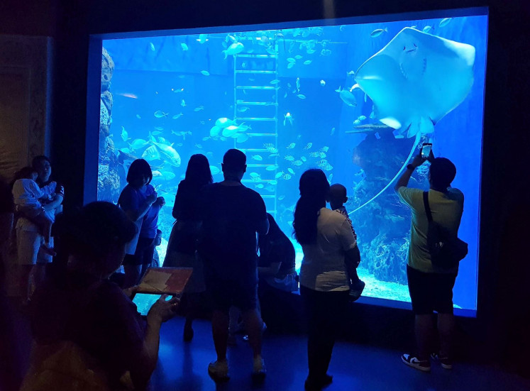 Picture perfect: Visitors take photographs in the Ocean Walkway exhibit at the Jakarta Aquarium that showcases a variety of small and large marine animals. 