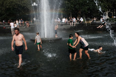 People try and stay cool in the fountain in Washington Square Park during the start of heat wave across the U.S. on July 19, 2019 in New York City.  