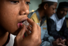 A student sucks an ice cube during the rehabilitation session to overcome his drug addiction. Aside from sucking on ice cubes, the students are also required to perform dzikir (chants in praise of God) during the therapy. JP/Aman Rochman