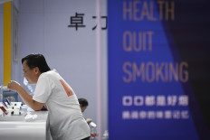 This file photo taken on June 28, 2019 shows a man smoking an electronic cigarette at the Beijing International Consumer Electronics Expo. 