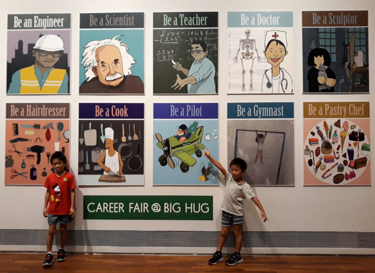 Embracing big ideas: Young visitors pose with a mosaic of posters at 'Big Hug', an interactive installation by husband-wife duo Milenko and Delia Prvački that uses paintings and ceramics to create a world packed with activities to spur the imagination.