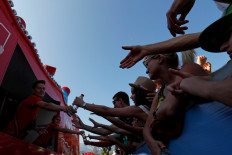 Staff of the publicity caravan carry out water bottles in the 208-km Stage 18 from Embrun to Valloire of the Tour de France on July 25, 2019.