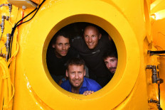 In this file photo taken on June 28, 2019 French biologist, marine naturalist and photographer Laurent Ballesta (down) poses inside his diving chamber ('station bathyale' in French) with his crew in Marseille. 