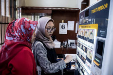 Two Indonesian Muslims are choosing halal ramen from a vending machine. JP/Rosa Panggabean