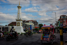 Sutopo drives his pedicab while passing the iconic Tugu Yogyakarta. JP/Anggertimur Lanang Tinarbuko