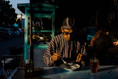 Before working, Sutopo eats breakfast at a nearby food stall. JP/Anggertimur Lanang Tinarbuko