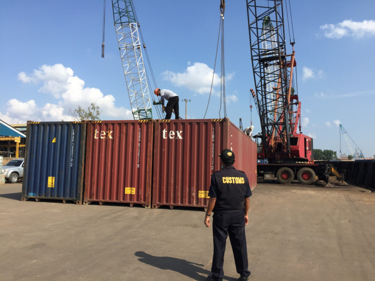 Batam Customs Office workers oversee the transfer of one of seven containers containing toxic and hazardous waste (B3 waste) to the Capricorn 97.210 Barge on July 29, 2019, at the Batu Ampar Container Port in Batam, Riau Islands.