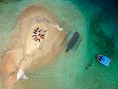 Surrounded by water: Tourists relax on Gili Kapal isle, otherwise known as the Gili Pasir isle in West Nusa Tenggara. When high tides come, it drowns the isle. 