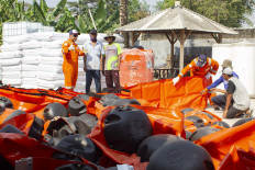 Workers prepare equipment to stop an oil spill caused by a leak in an oil well operated by state oil and gas company Pertamina in the ONWJ Block in Karawang, West Java.
