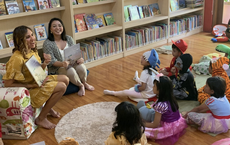 Igniting imaginations: Kirli read her book with a translator at Rimba Baca to a group of children paying rapt attention. 