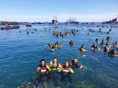 Divers emerge from the water after breaking the Guinness World Record for most people scuba diving simultaneously on Saturday, Aug. 3, 2019, during the Indonesian Women Divers (WASI) official attempt  at Megamas Beach in Manado, North Sulawesi. The group broke three Guinness records on Aug. 1-3.