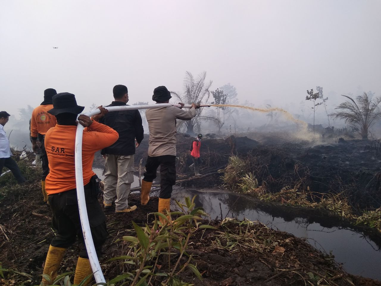 Officials from the search and rescue agency in Jambi try to put out fires in the region.