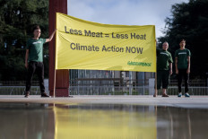 Greenpeace activists hold a banner reading 'Less Meat : Less Heat, Climate Action Now', during a protest prior to the publication by The UN's Intergovernmental Panel on Climate Change (IPCC) of a special report on climate change and land on August 8, 2019 in Geneva. 