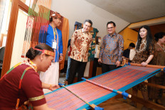 Business with a purpose: Maybank Indonesia President Director Taswin Zakaria (center), accompanied by Maybank Group President and Chief Executive Officer Datuk Abdul Farid Alias (second right) and Maybank Indonesia community financial services director Jenny Wiriyanto (right), observes a local craftswoman weaving during an exhibition showcasing small-to-medium enterprises who benefit from Maybank Indonesia&rsquo;s corporate responsibility program.
