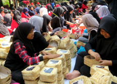 Students at SMP 3 state junior high school in Malang, East Java, place "qurban" (sacrificial) meat into dozens of 'besek' (containers made of plaited bamboo) to be distributed to people in need on Sunday.