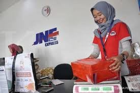 A staff of courier service provider PT Tiki Jalur Nugraha Ekakurir, more commonly known as JNE, checks on a package ready for shipment in this photo illustration.
