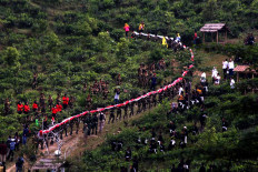 Members of Banser carry the giant flag up Sumilir valley in Karanganyar, Central Java, on Aug. 1. JP/Maksum Nur Fauzan