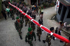 Members of the Indonesian Army (TNI), police and civilian security unit under the Nahdlatul Ulama’s Ansor youth wing, Barisan Ansor Serbaguna (Banser), carry a 30-by-40-meter national flag at Sumilir Valley in Karanganyar, Central Java, on Aug. 1. JP/Maksum Nur Fauzan