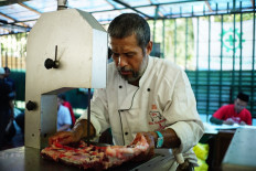 An attendant cuts qurban (sacrificial) meat at Istiqlal Mosque in Central Jakarta on Sunday. The cutting process used both a conventional technique and meat cutters. JP/Syelanita