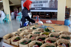A woman prepares qurban (sacrificial) meat in besek (containers made of plaited bamboo) to be distributed to the public on Sunday at the Blitar Police headquarters in Blitar, Talun district, East Java. The Blitar Police also promoted the use of besek in distributing qurban meat to reduce plastic waste. JP/Asip Hasani
