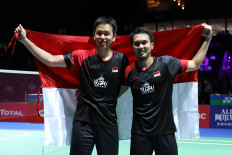 Indonesian shuttlers Hendra Setiawan (left) and Mohammad Ahsan celebrate on Aug. 25, 2019, after winning their third BWF World Championships title in men's doubles in Basel, Switzerland.
