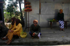 Villagers take a rest while waiting for a parade to arrive. JP/Maksum Nur Fauzan