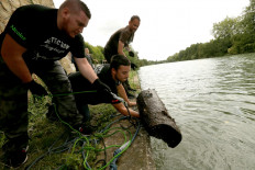 Fishermen remove scrap metal they caught with a 'super-powerful' neodyme magnet from the Oise river in Lacroix-Saint-Ouen, northern France, on August 16, 2019. 