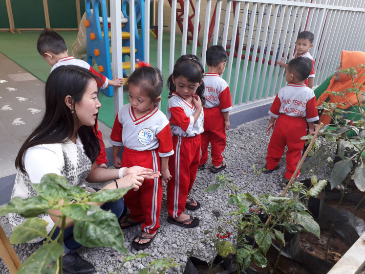 Djarum Foundation's Education Program Manager Felicia Hanitio (left) chats with students of PAUD Terpadu Kalirejo after the children finish watering plants, conducted as part of the Jumat Bersih (Clean Friday) activity held every Friday at the school.