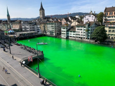 This handout picture released by the Swiss police of the city of Zurich (Stadtpolizei Zurich) shows the Limmat river dyed green during a demonstration by Extinction Rebellion Zurich at midday in the center of the city on September 10, 2019. 