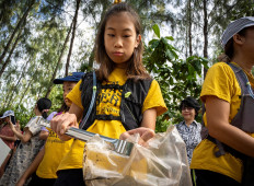In this picture taken on August 25, 2019, 12-year-old Ralyn Satidtanasarn, known by her nickname Lilly, collects plastic waste during the Trash Hero cleaning initiative at the Khung Bang Kachao urban forest and beach in Bangkok. 