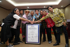 United commitment: Industry Ministry director general of chemical, textile and miscellaneous industries Achmad Sigit Dwiwahjono (center) and Asia Pacific Rayon director Basrie Kamba (second right) pose with stakeholders from the textile and fashion industries on Sept. 6, 2019 during a signing ceremony at the Unigraha Hotel in Pangkalan Kerinci, Riau. Government and industry representatives signed a memorandum of understanding (MoU) on the use of local, sustainably  produced rayon in a bid to revitalize the Indonesian textile industry toward global competition.