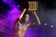 A competitor flaunts his biceps by lifting a number of roof tiles during the 2019 Jatiwangi Cup bodybuilding championship at the Dua Saudara jebor in Burujul Kulon, Majalengka, West Java, recently. The winner of the championship is not allowed to compete in the next championship. JP/Arya Dipa