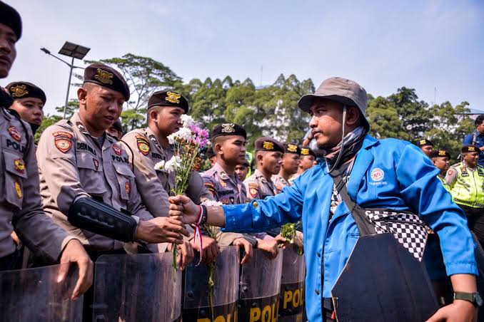 Flower power: Students in Jakarta hand out blossoms as sign of peaceful protests