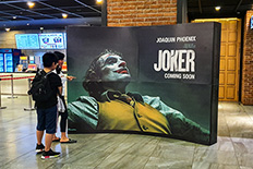 Clueless: A mother and her son look around a Joker movie standee in one of the theaters in Central Jakarta, Thursday, Oct. 10.