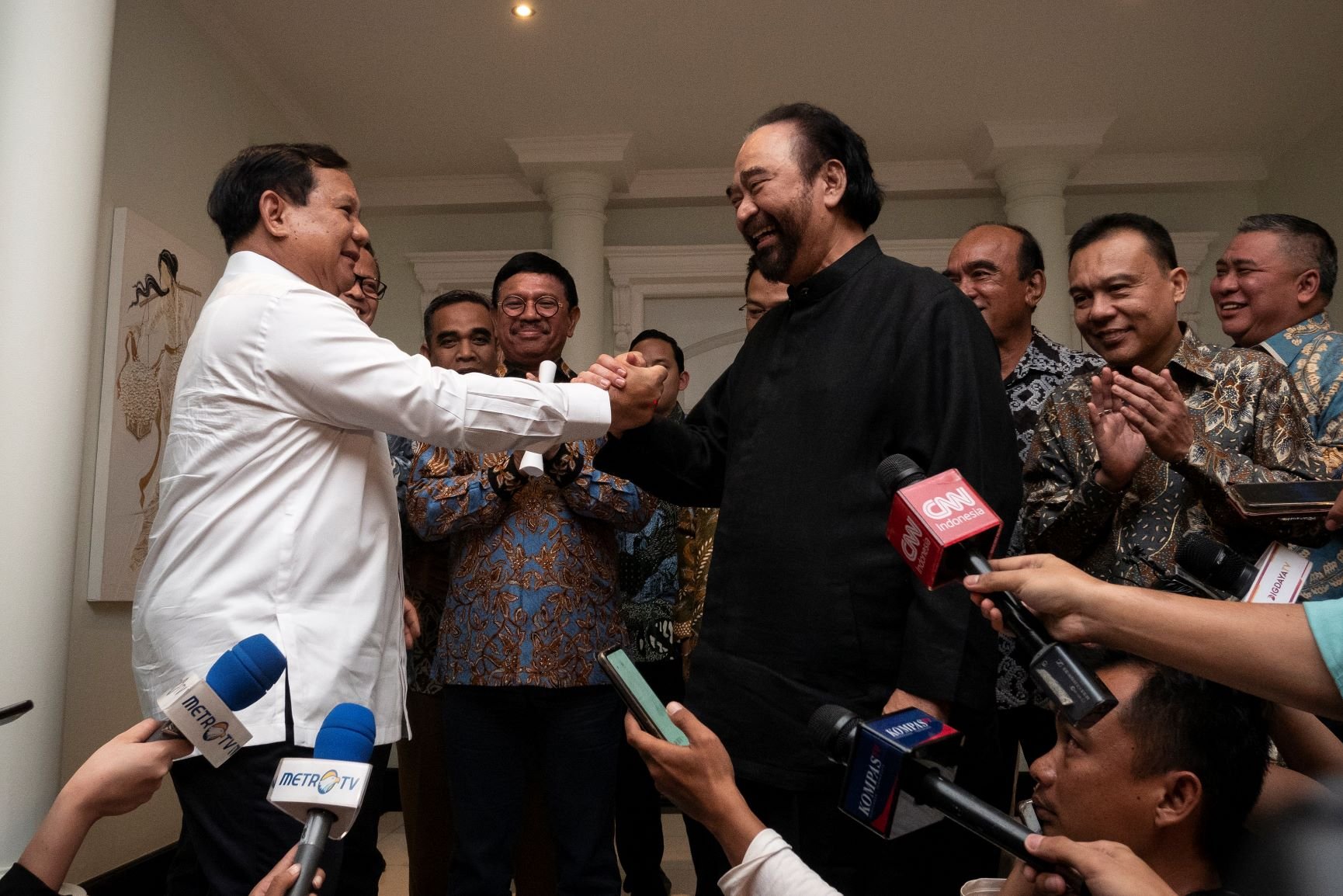 Gerindra Party chairman Prabowo Subianto (left) holds hands with NasDem Party chairman Surya Paloh on Oct. 13. 