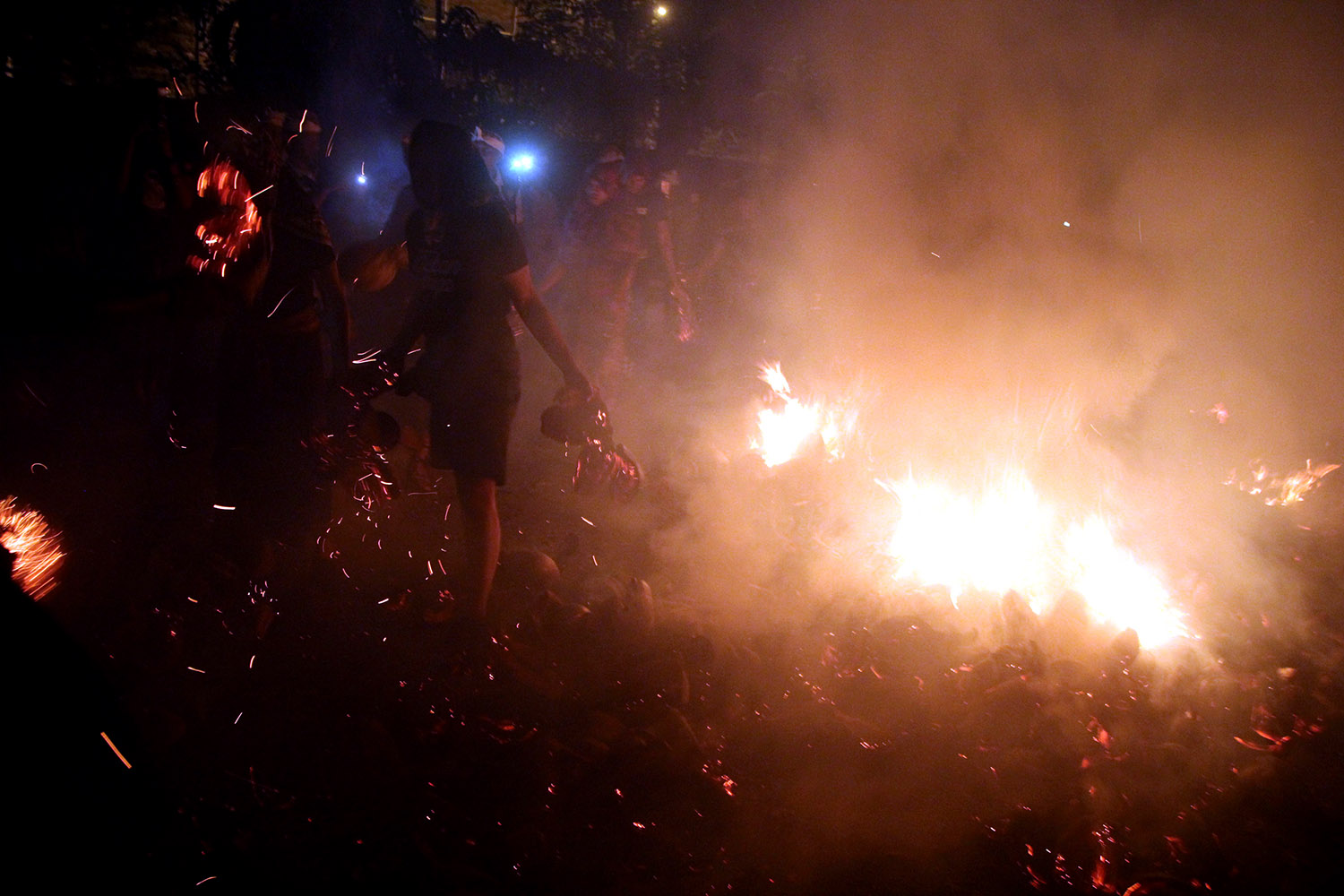 Participants bring coconut husks that have turned into an ember during the mesiat geni tradition. JP/Zul Trio Anggono